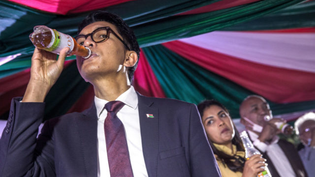 TOPSHOT - Madagascar's President Andry Rajoelina drinks a sample of the "Covid Organics" or CVO remedy at a launch ceremony in Antananarivo on April 20, 2020. "Covid Organics" or CVO is a remedy produced by the Malagasy Institute of Applied Research (IMRA) created from the Artemisia plant and supposedly help to prevent any infection caused by the new coronavirus Covid-19. (Photo by RIJASOLO / AFP) (Photo by RIJASOLO/AFP via Getty Images)
