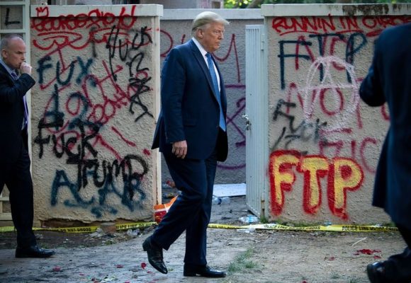 President Donald Trump Walks Past Graffiti Insulting Him