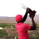 Lifting the glass trophy high, after conquering the course, Tonderai Kajese beyond the mountains.