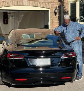 Miguna Miguna poses with his Tesla electric vehicle he attributed to his law firm KMM Lawyers