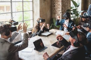 Group of businessperson exploring a virtual project wearing 360 3d vr goggles and sitting around the table - people meets in metaverse reality - business lifestyle concept