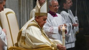 Ailing Pope Francis, head of the Roman Catholic Church celebrates Easter Vigil mass, lighting a candle.
