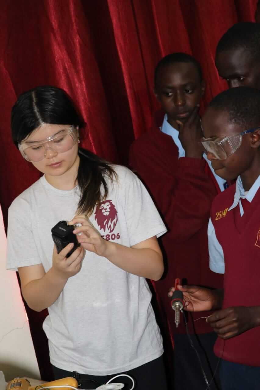 Ellen Wang from Horace Mann School shows Mang'u High School students how to safely use tools