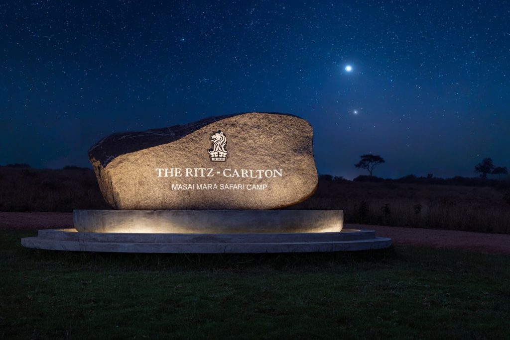 An illuminated entrance marker welcomes guests to the Ritz-Carlton Maasai Mara Safari Camp under a star-filled sky. Courtesy of Ritz-Carlton Hotel.