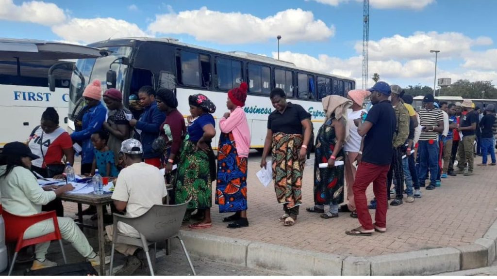 Malawian and Zimbabwean nationals queue for processing for deportation at the Beitbridge Border Post in Musina, Limpopo, June 2026. Officials said several buses carrying migrants arrived from Cape Town and Johannesburg, with some passengers reporting they had been travelling since Tuesday. More than 15,000 Malawians were processed for deportation through Beitbridge in the weeks surrounding the June 30 Afrophobia marches. Not one organizer of those marches has been charged. Photo: Vutivi Maluleke / SABC News.