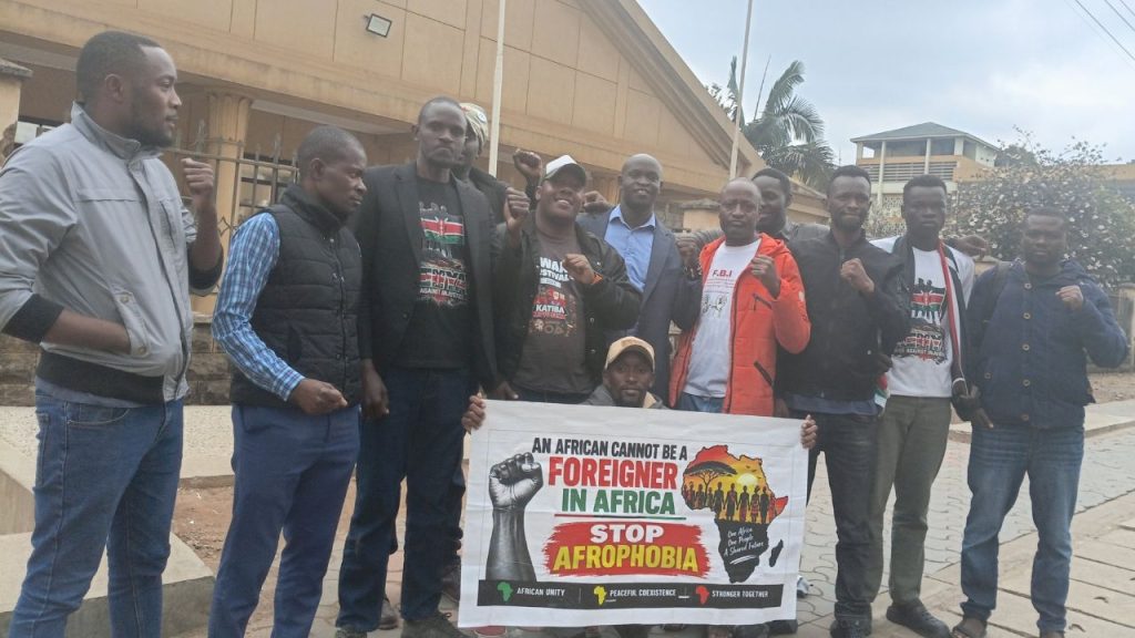 Kenyan activists raise their fists behind a banner reading 'An African Cannot Be a Foreigner in Africa' during a demonstration against xenophobia.